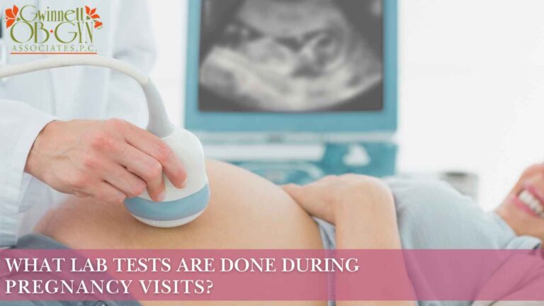 Medical professional performing prenatal testing ultrasound on pregnant patient with ultrasound monitor visible